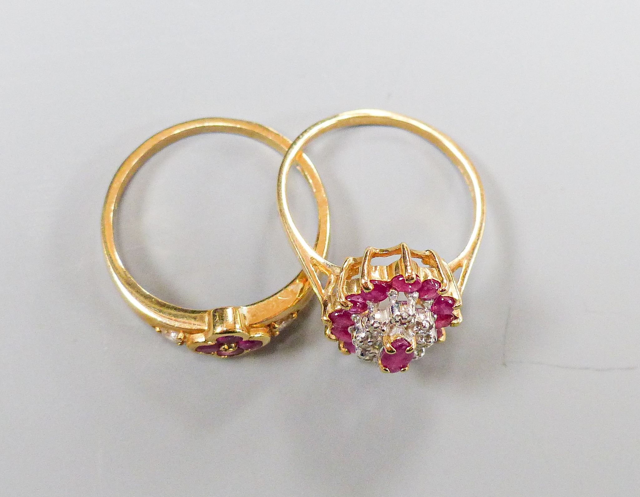 A 9ct yellow gold, ruby and diamond oval cluster ring, size M and another similar 9ct ring, gross 4.5 grams.